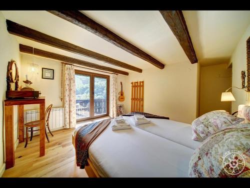 - une chambre avec un lit, un bureau et une fenêtre dans l'établissement CASA SANT BLAS de Alma de Nieve, à Gessa