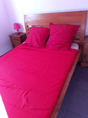 een groot bed met roze lakens en kussens bij chez laly et mimy in La Possession