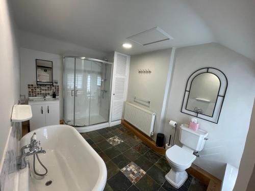 a bathroom with a tub and a toilet and a sink at Charming & Idyllic Grade 2 Listed Cottage for 6 Pass the Keys in Stony Middleton