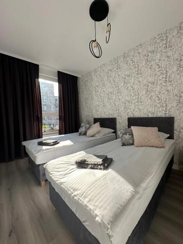 a bedroom with two beds and a wall at SkyTravel 27 Apartament Pileckiego Nowy Dwór Mazowiecki Airport Modlin 24H in Nowy Dwór Mazowiecki