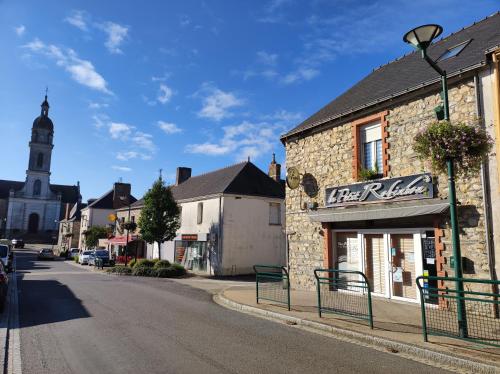 a street in a small town with a clock tower at Chambre chez l'habitante "Bambou" in Derval