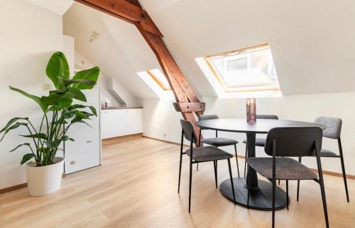 uma sala de jantar com mesa e cadeiras e uma planta em Cosy apartment Antwerpen center2 em Antuérpia