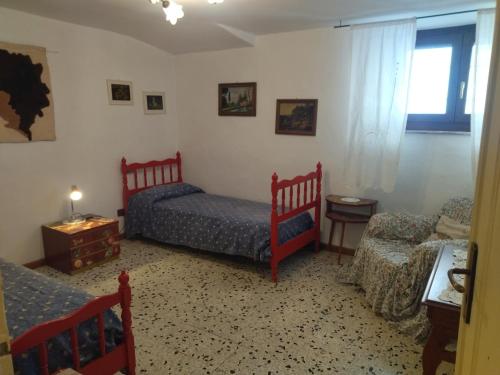 a bedroom with two beds and a table and a chair at Casetta Edera in Allerona