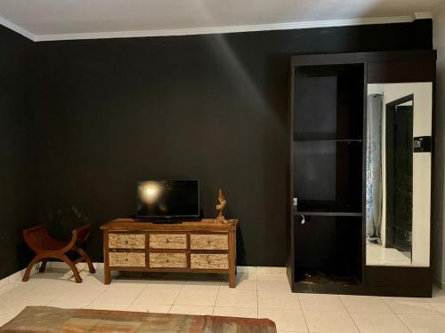 a living room with a black wall and a television on a table at Villa Lanikki 3 bedrooms 4 bathrooms Seminyak in Legian