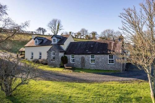 an old stone house in a field of grass at Foxen Holes Cottage in Saundersfoot