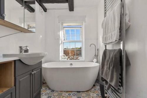 a bathroom with a large white tub and a sink at The Annex in Saundersfoot