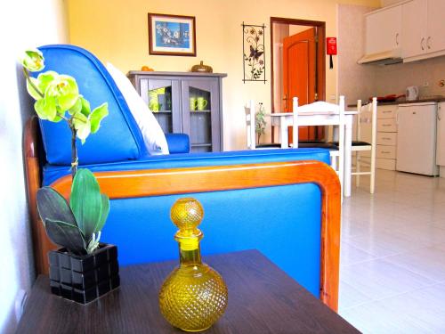 a blue bed with a vase on a table at Casa da Horta, Vale carro Olhos de Agua in Albufeira