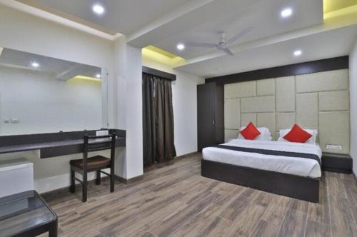 a hotel room with a bed and a desk and a desk at Hotel Grand Ambience in Gandhidham