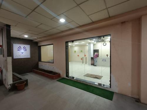 Habitación con una gran ventana de cristal en un edificio en Hotel Grand Ambience en Gandhidham