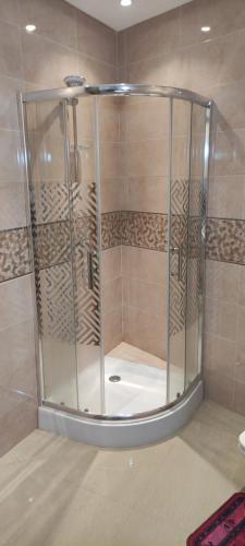 a shower with a glass enclosure in a bathroom at APPARTEMENT haut standing in Ben Slimane