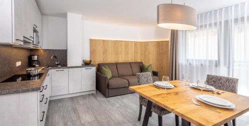 盧塔戈的住宿－Zum Sonnentor App Larix，厨房以及带桌子和沙发的用餐室。