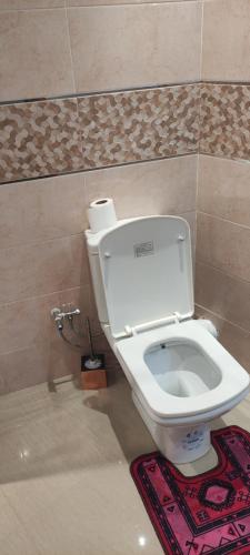 a white toilet in a bathroom with a rug at APPARTEMENT haut standing in O Ben Slimane