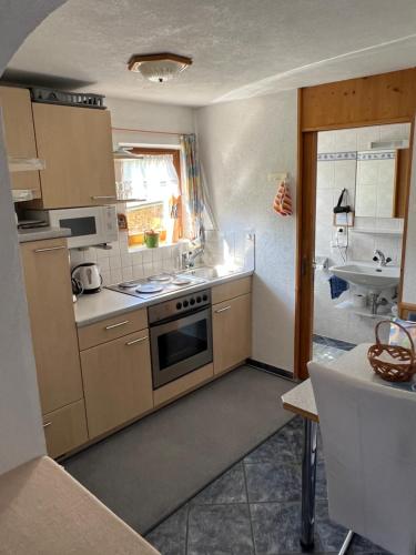 uma cozinha com um lavatório e um fogão forno superior em Haus Ritter 286 em Schoppernau