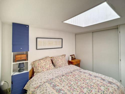 une chambre avec un lit et une lucarne dans l'établissement Petite maison à la plage dans résidence naturiste, à Leucate