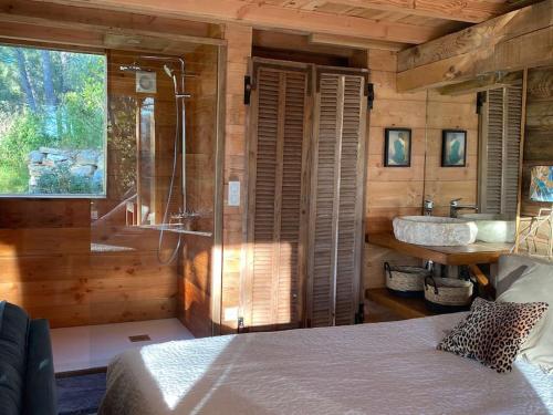 a bedroom with a bed and a bathroom with a sink at logement entier atypique à Cassis in Cassis
