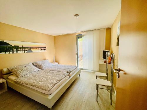- une chambre avec un lit, une fenêtre et une chaise dans l'établissement Seemöwe, à Uhldingen-Mühlhofen
