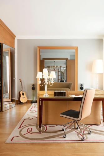 an office with a desk and a chair and a mirror at Hôtel Le Royal Monceau Raffles Paris in Paris