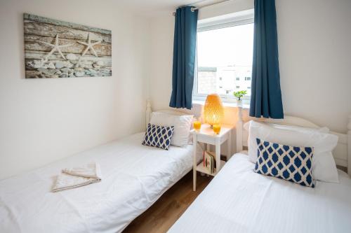 2 letti in una piccola camera con finestra di Stunning 2 bed seaside apartment with Sea Views a Bournemouth
