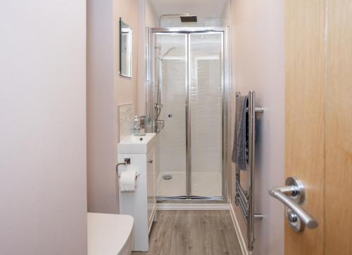 e bagno con doccia, servizi igienici e lavandino. di Stunning 2 bed seaside apartment with Sea Views a Bournemouth