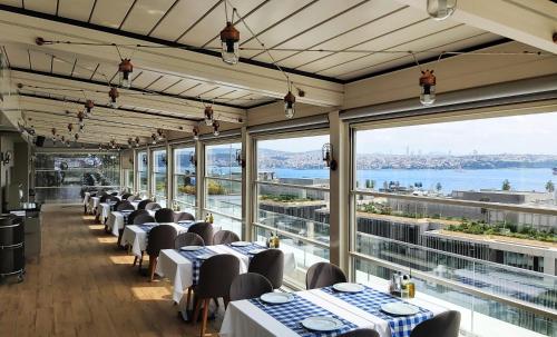 a restaurant with tables and chairs and large windows at Port Bosphorus Hotel in Istanbul