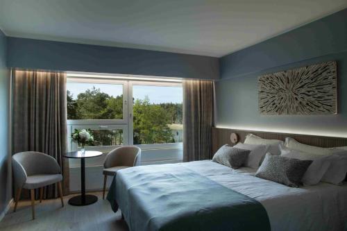 a bedroom with a large bed and a window at Ruissalo Spa Hotel in Turku