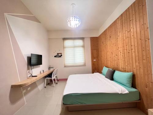 馬公市的住宿－樂在綺中民宿 第580號，一间卧室配有一张床、一张书桌和一台电视