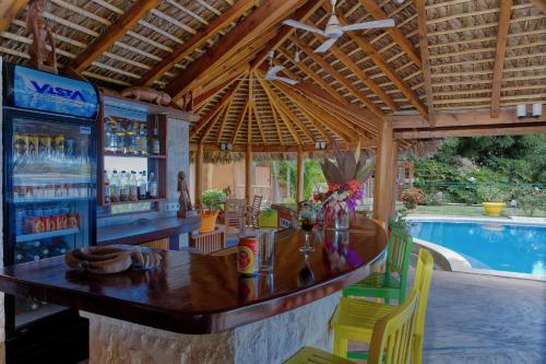 a bar in a resort with a swimming pool at VILLA PANORAMA NOSY BE in Nosy Be