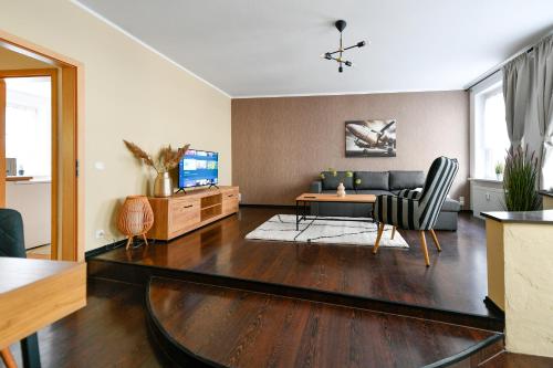 un soggiorno con un divano e un tavolo di Modernes Altmarkt Apartment mit Parkplatz 4 Gäste 55qm Waschmaschine Wlan Netflix Terrasse a Cottbus