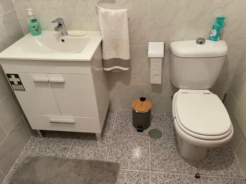 uma casa de banho com um WC branco e um lavatório. em O Nosso Recanto em Machico