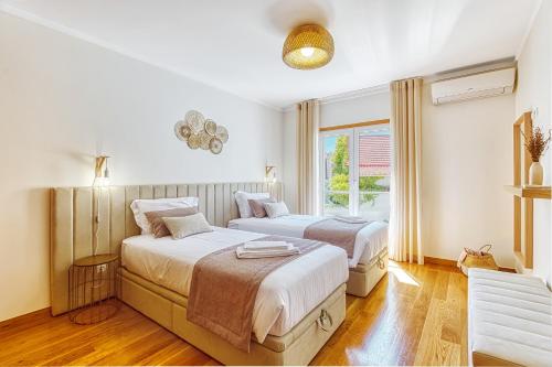 um quarto com 2 camas e uma janela em Stunning House with Terrace em Lisboa