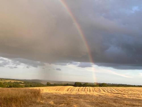a rainbow in the sky over a field at Bedport Loft in Burrington