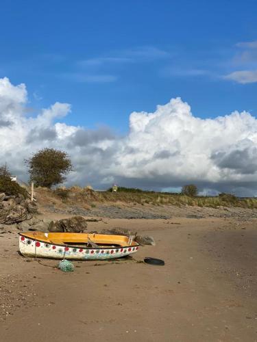 a boat sitting on the sand on a beach at Bedport Loft in Burrington