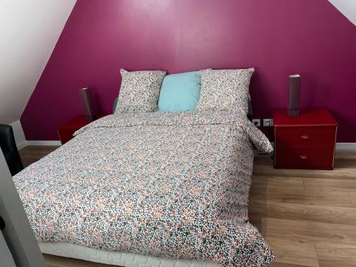 1 dormitorio con cama y pared púrpura en Maison Le grand sapin , 5min du zoo parc de Beauval, en Saint-Aignan