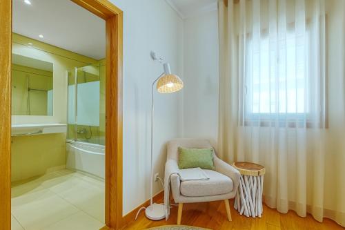 uma casa de banho com uma cadeira e um espelho em Stunning House with Terrace em Lisboa