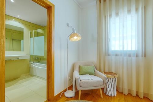 a bathroom with a chair and a mirror at Lisbon Stunning House with Terrace in Lisbon