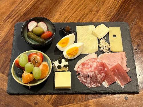 a tray of food with different types of cheese and fruit at MuziKafe - Home of Culture in Ptuj