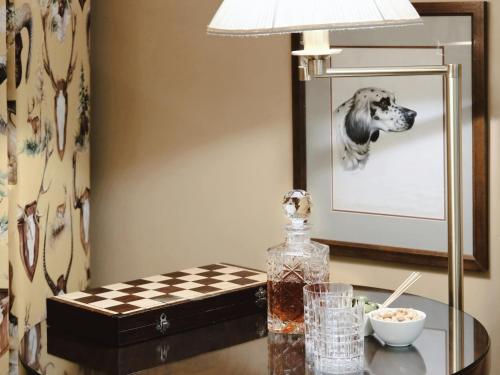 a table with a lamp and a picture of a dog at Stikliai Hotel - Relais & Châteaux in Vilnius