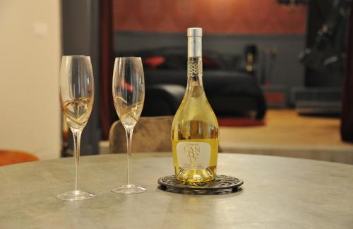 a bottle of wine sitting on a table with two wine glasses at L'Un Des Sens in Châtel-Guyon