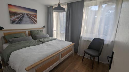 1 dormitorio con 1 cama y 1 silla en Allroom: Moderne Eleganz trifft Vintage-Chic!, en Unterschleißheim