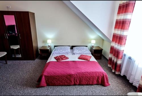 sypialnia z dużym łóżkiem i różowym kocem w obiekcie Zajazd Laguna w mieście Trojanów
