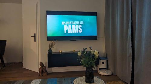 a flat screen tv on a wall in a living room at ALLROOM Modernes Apartment in Unterschleißheim Nur 20 Minuten nach München in Unterschleißheim
