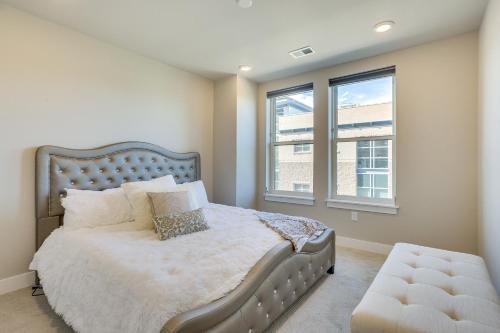 um quarto com uma cama grande e 2 janelas em Castle Rock Condo - Walk to Dining and Shopping! em Castle Rock