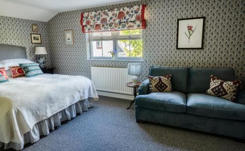 a bedroom with a bed and a couch and a window at George and Dragon Clifton in Penrith