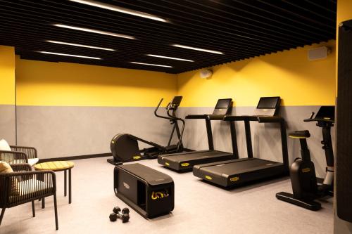 a gym with treadmills and exercise equipment in a room at Le Parchamp, a Tribute Portfolio Hotel, Paris Boulogne in Boulogne-Billancourt