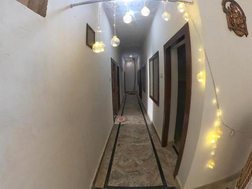 a hallway with lights on the walls of a building at Karma Hostel in Khajurāho