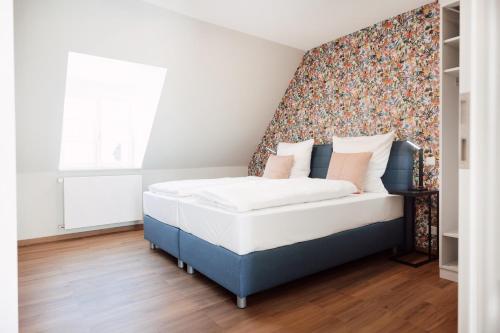 a bedroom with a bed with a floral accent wall at House of Blooms in Fulda