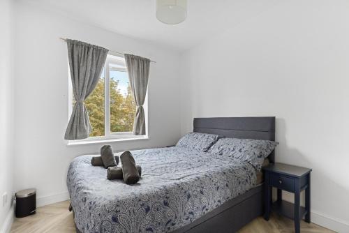 a bedroom with a bed with a pair of shoes on it at Tranquil 1 Bed Flat in East London in London