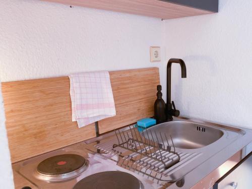 - un évier de cuisine avec un séchoir à vaisselle dans l'établissement Central Apartment Rhein Neuss-Düsseldorf Messe, à Neuss