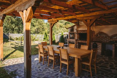 une table et des chaises en bois sur une terrasse avec une cheminée dans l'établissement MMexperience, à Bîrsana