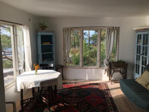 a living room with a table and two windows at Sjöstuga, Archipelago Beach House in Värmdö